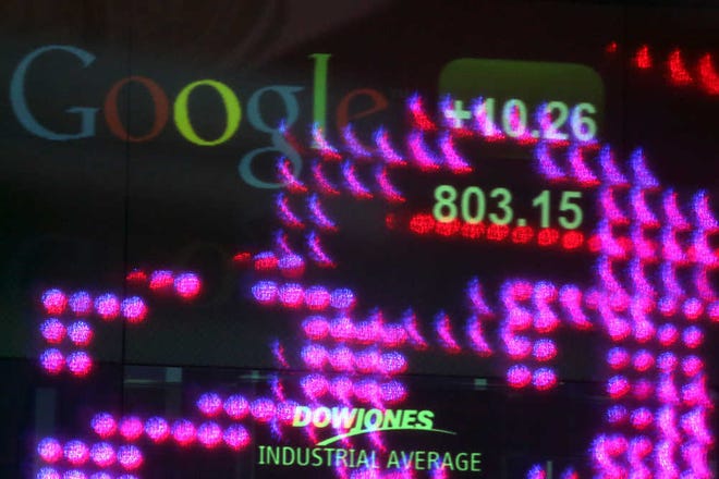 The Google logo and numbers are displayed on a ticker behind Time Square lights reflected on NASDAQ headquarters windows Tuesday in New York.  Google's stock price topped $800 for the first time Tuesday, Feb. 19, 2013, amid renewed confidence in the company's ability to reap steadily higher profits from its dominance of Internet search and prominence in the increasingly important mobile device market. (AP Photo/Mary Altaffer)