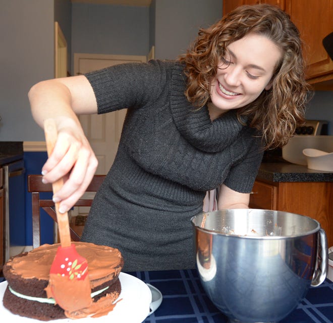 Hannah Muthersbaugh, February’s Cook of the Month, spreads icing on her Chocolate Mint Cake.