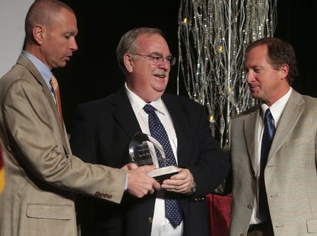 Paul Wohlford, left, interim president of the Panama City Beach Chamber of Commerce, and Derrick Bennett, right, 2013 chairman of the board, present the Beach Chamber Pioneer of the Year Award to John Paul “Jack” Bishop Jr. Thursday at the 2013 Annual Awards Dinner.