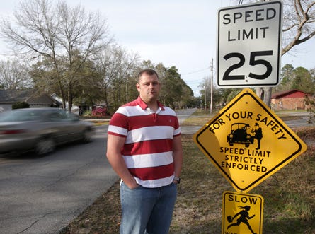 Sean McGann stands beside a speed limit sign near his home on Colorado Avenue in Lynn Haven. McGann and his wife are considering moving because of the safety issues associated with what he says is a lack of speed limit enforcement.
