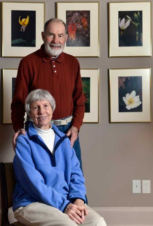 Botanical photographers Hugh Nourse, top, and wife Carol Nourse, pose for a picture with some of their photos behind them in their home in Athens, Ga. on Tuesday, Feb. 19, 2013.  (Richard Hamm/Staff) OnlineAthens / Athens Banner-Herald