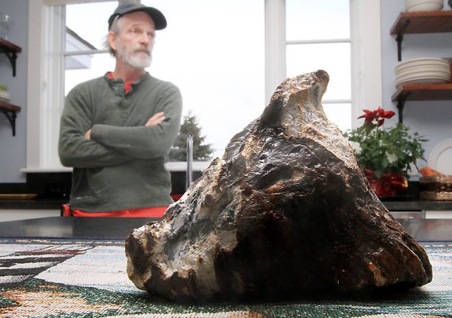 Rye, N.H. fisherman Mike Anderson says he pulled up a mammoth tooth from the depths of the ocean Tuesday, Feb. 19, 2013. Anderson said he was fishing for scallops near Rye Harbor on Tuesday. He noticed a 6-inch-long, triangular object mixed in with the scallop shells and rocks. Will Clyde, a University of New Hampshire associate professor of geology, says it may be a fossil mammoth tooth. (AP Photo/Portsmouth Herald, Ioanna Raptis)
