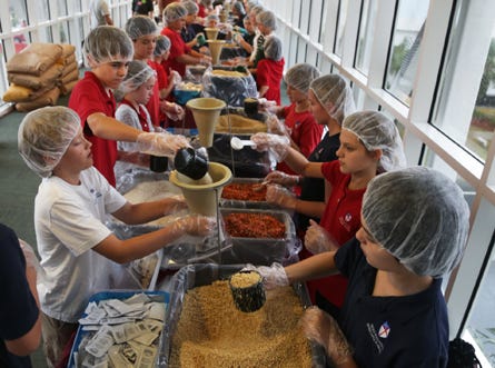 Students from Holy Nativity Episcopal School prepare meals while volunteering during a meal-packing event through the Stop Hunger Now organization Friday at the Majestic Beach Resort in Panama City Beach.