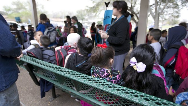 Children line up after school waiting to be picked up at Cook Elementary.