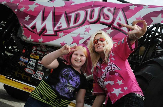 Kelly.Jordan@jacksonville.com Chloeanna Beaudoin, 7, of Jacksonville, poses with the driver of Madusa, Debrah Miceli. Beaudoin dyed her hair pink to support her favorite driver during the Monster Jam pit party at EverBank Field on Saturday.