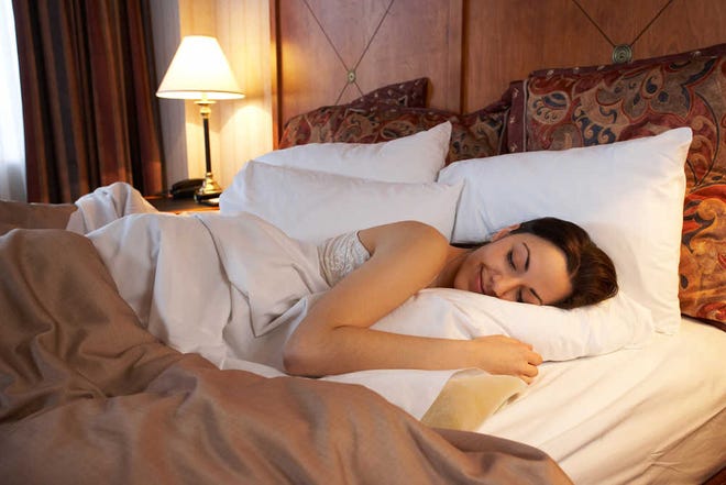 Woman sleeping in hotel bed