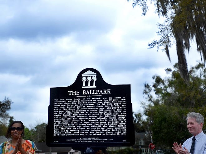 Gigi Simmons (from left) and Mayor Craig Lowe  participate in the unveiling of the “The Ballpark” historical marker at Porters Community Center on Saturday, February 23 in Gainesville, Fla.(ASHLEY CRANE/ Correspondent)