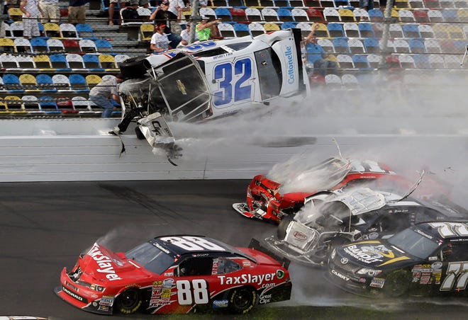 Kyle Larson (32) goes airborne and into the catch fence in a multi-car crash involving Dale Earnhardt Jr. (88), Parker Kilgerman (77), Justin Allgaier (31) and Brian Scott (2) during the final lap of the NASCAR Nationwide Series auto race at Daytona International Speedway, Saturday, Feb. 23, 2013, in Daytona Beach, Fla.