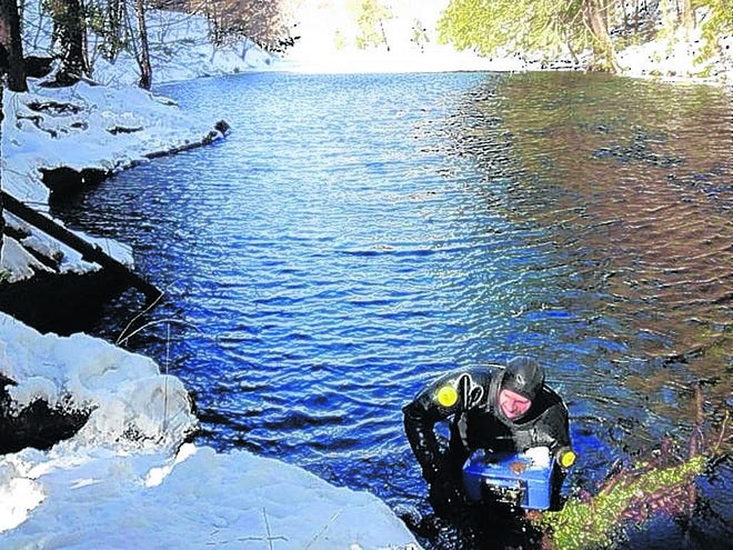 Police needed to retrieve a safe, stolen in Denning, to build their case, so dive teams braved cold river waters Thursday. Trooper Joseph Benziger carries the safe up the riverbank.