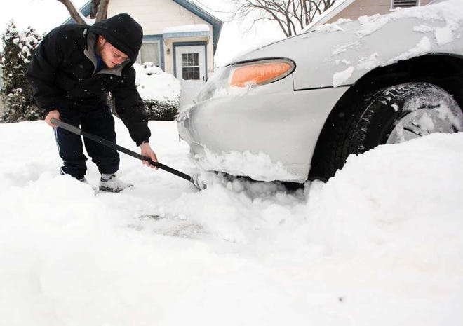 Allen Cessna digs out his car to move it to the other side of the street Friday, Feb. 22, 2013, morning on East Howard Street in Winona, Minn. At least 6 inches of new snow fell Thursday night and Friday. (AP Photo/Winona Daily News, Andrew Link) MANDATORY CREDIT
