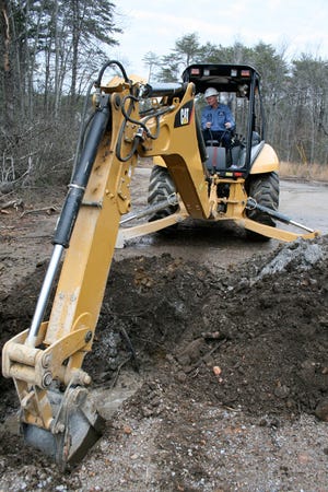 Paul Smith of the Gadsden Water Works and Sewer Board operates a backhoe Monday at the site of a new water line on Marjorie Circle. He dug a hole to show the depth of the pipe and the layers construction crews had to dig through to lay the 800 feet of water line.