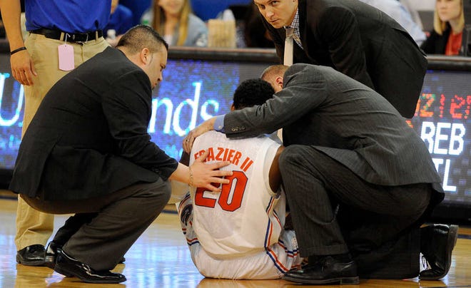 Dr. Kevin Farmer, left, and the Florida medical staff care for Michael Frazier II after he was injured Saturday against Arkansas.