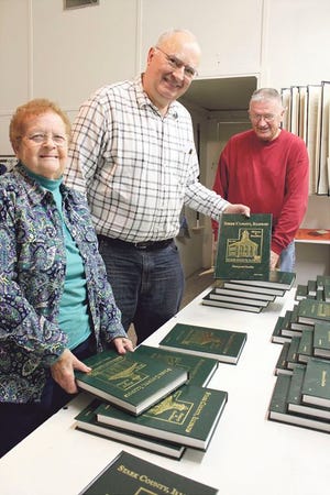The new Stark County History and Families book has arrived in Toulon at the Stark County Genealogical Society. Checking the books are club members (from left) Janet Johnson, Don Schmidt and Floyd Ham.
