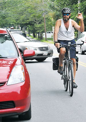 8/22 NE - Bob Jampol, a Waban resident and a Newton South English teacher, signals as he turns into the Newton Farmers' Market at Cold Spring Park on Tuesday, August 14. After pulling into the free valet bicycle parking he said he rides to the location because it is his 'conveyance of preference, helps keep him healthy, and it's good for the environment."
