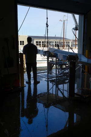 Joe Ventimiglia, from Gloucester, waits near the dock for a fishing boat to arrive to off loaded while at Fisherman's Wharf in Gloucester. Fishing regulations continue to affect the fishing industry in Gloucester.