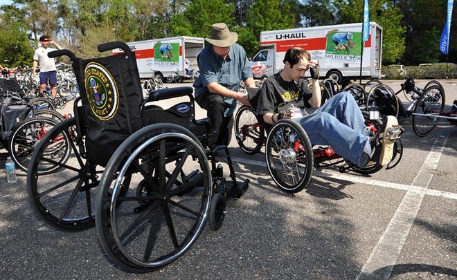 Hal Honeyman adjusts the bicycle for Daniel Nardy, right, after a test ride on Thursday, February 28, 2013, at the Sawgrass Marriott in Ponte Vedra Beach, Florida. The Navy veteran pulled up next to his wheelchair after the loop around the parking lot. Warriors arrived for bike fittings for the Wounded Warrior's Solider Ride.