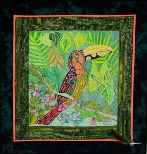 A toucan inspired fiber art by Vickie Mathas, who has works on view at the Home Fine Art Gallery.