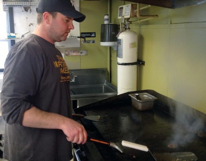 Pat McConney, owner of Just Steaks, works at the grill in his kitchen in Riverside last week.