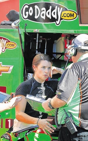 Danica Patrick talks with a team member in the garage area during practice for the NASCAR Sprint Cup Series auto race, Saturday, March 2, 2013, in Avondale, Ariz. (AP Photo/Ross D. Franklin)