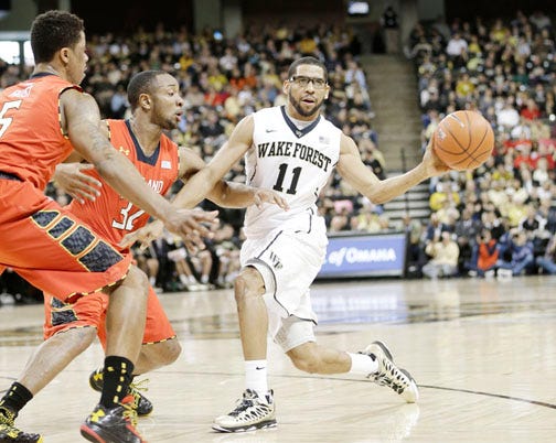 Wake Forest's C.J. Harris passes while Maryland's Nick Faust, front left, and Dez Wells defend on the play.