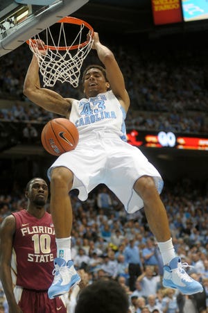 North Carolina's James Michael McAdoo dunks while Florida State's Okaro White watches during Sunday afternoon's game in Chapel Hill.
