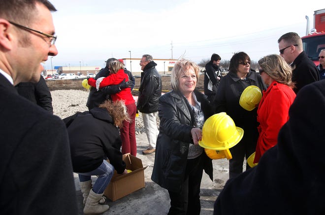 Karen Jeffers hands out commemorative yellow hard hats before the groundbreaking took place Monday afternoon. Steve and Karen Jeffers of Springfield, who started in high school as crew members at McDonald's, broke ground along with their family members, associates and city officials for their second restaurant on Monday, March 4, 2013 at 4301 W. Wabash Ave. next to Qik 'n' EZ.