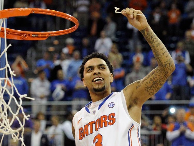 Florida guard Mike Rosario (3) holds up a piece of the net after Florida defeated Vanderbilt 66-40 to clinch the SEC regular-season title in the Gators' final home game in Gainesville.