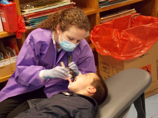 Dentist Laura Therman screens a student’s teeth at Donaldsonville Primary School last week during the “Give the kids a Smile Day.”