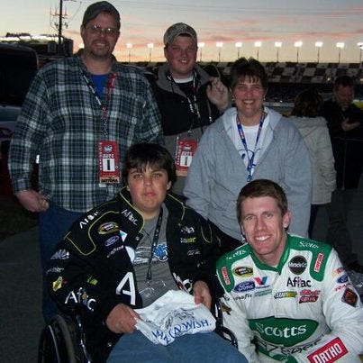 Carl Edwards (lower right) spends a lot of time with his fans. After
breaking his 70 race winless drought, Carl went into the PIR grandstands to mix it up with the fans before he went the to Phoenix Intl. Raceway's victory lane.