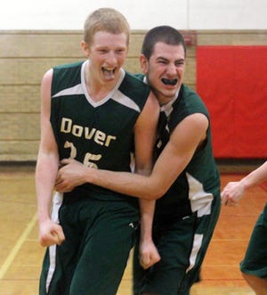 Dover's Billy Carroll, left, gets a bear hug from teammate Phil Boyatsis after the Green Wave's 61-60 upset win over Memorial in Division I tournament action Tuesday night in Manchester.