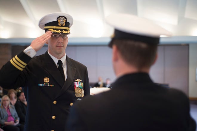 Cmdr. Louis Springer salutes Capt. Christopher Harkins during the USS Rhode Island Blue crew change of command.