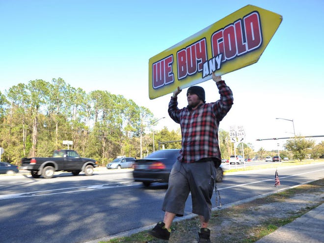 Casey Lane, 20, spins a sign on Southwest Second Avenue in Gainesville, Fla., on Wednesay, March 6, 2013. About his job, Lane said, "If I get a few people to wave or laugh, it makes my day."