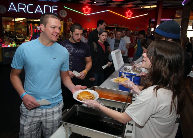 Jake Brasdovich is served a plate of pancakes by Kelsi Clark at Rock 'It Lanes in Panama City Beach on Monday. .