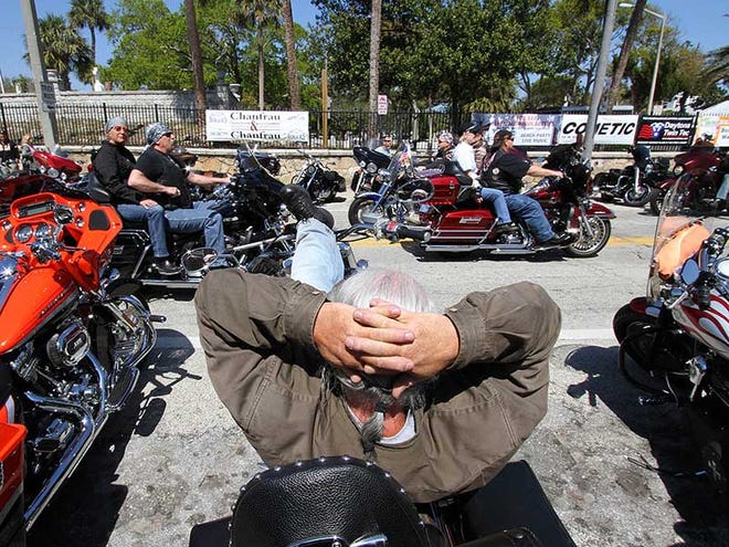 Fred Francisco kicks back on a motorcycle parked along Main Street in Daytona Beach to watch Bike Week 2013 roll past Friday, Mar. 8, 2013.
