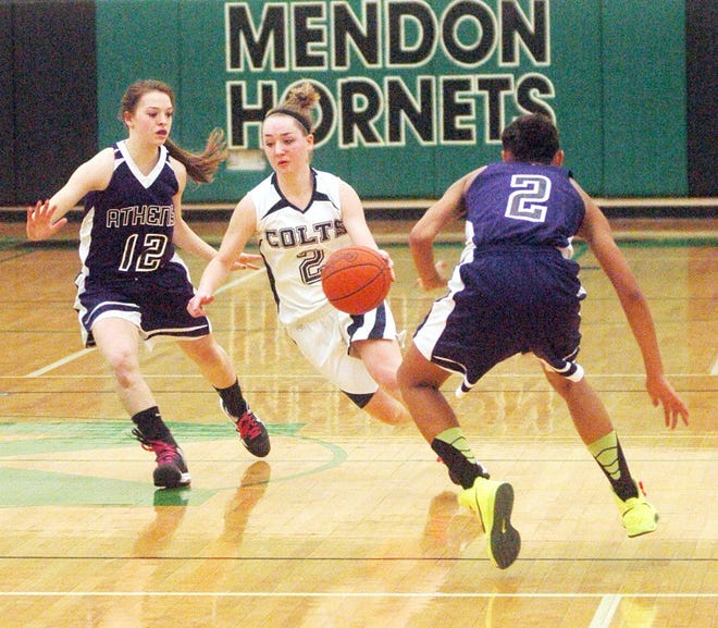 Hillsdale Academy senior Elyse Lisznyai splits two Athens defenders as she brings the ball up the court during Thursday night's Class D Regional Final game at Mendon High School. Andy Barrand photo