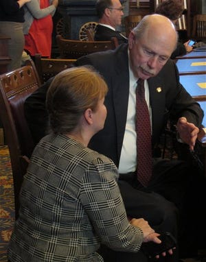 Kansas state Sen. Les Donovan, right, a Wichita Republican and chairman of the Senate Assessment and Taxation Committee, talks to Sen. Caryn Tyson, left, a Parker Republican, during the chamber's session, Monday, Feb. 4, 2013, at the Statehouse in Topeka, Kan. Tyson serves on the tax committee, which is considering proposals from Gov. Sam Brownback. (AP Photo/John Hanna)