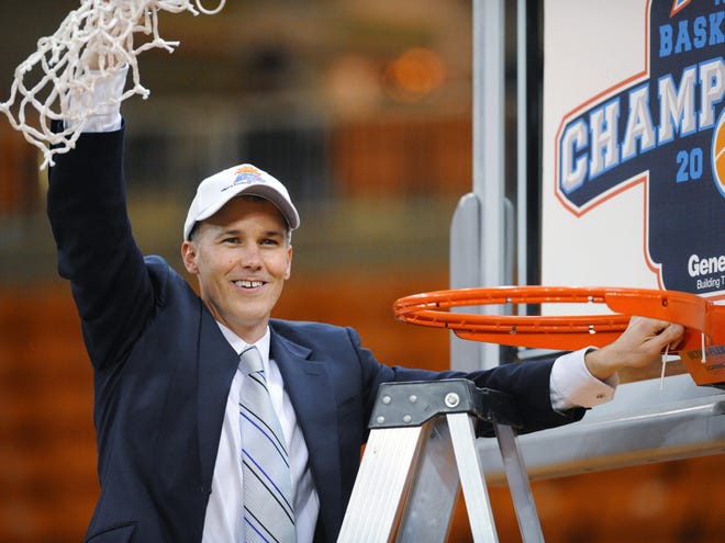 Florida Gulf Coast coach Andy Enfield holds up the net after his team defeated Mercer in the Atlantic Sun men's tournament championship Saturday in Macon, Ga. Florida Gulf Coast won 88-75.