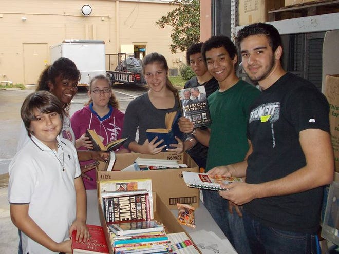 T-Club members sort books to deliver to various places around Flagler County. Clockwise from left, Ethan Meister, Silvia Purcer, Wilhemina Anderson, Serinna Meister, Jeremy and Joshua Manoi and Tristan Meister are just some of the members of the proactive teen club.