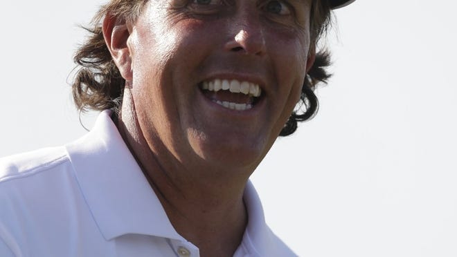 Phil Mickelson smiles on the ninth green after finishing the second round of the Cadillac Championship golf tournament Friday, March 8, 2013, in Doral, Fla. (AP Photo/Wilfredo Lee)