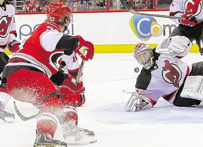 New Jersey Devils' goalie Johan Hedberg, of Sweden, stops a shot by Carolina Hurricanes' Jeff Skinner, left, during the second period of an NHL hockey game in Raleigh, N.C., Saturday, March 9, 2013. (AP Photo/Ted Richardson)
