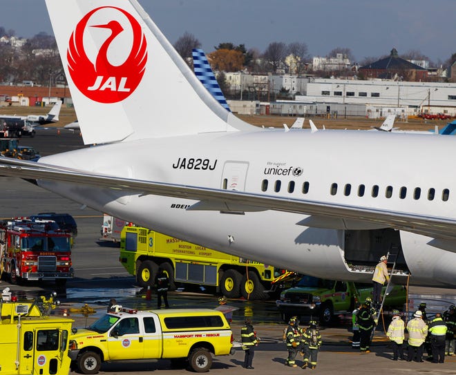 FILE - In this Jan. 7, 2013, file photo, a Japan Airlines Boeing 787 jet aircraft is surrounded by emergency vehicles while parked at a terminal E gate at Logan International Airport in Boston as a fire chief looks into the cargo hold. Federal regulators have approved a Boeing plan to redesign the fire-prone lithium-ion batteries, although extensive testing will be needed before the planes can fly passengers again. The Federal Aviation Administration said Tuesday, March 12, 2013, the plan includes a redesign of the internal battery components to minimize the possibility of short-circuiting, better insulation of the battery's eight cells and the addition of a new containment and venting system.(AP Photo/Stephan Savoia)