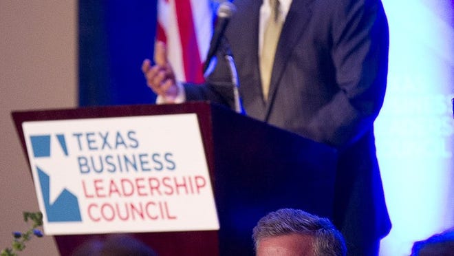 As former Florida Gov. Jeb Bush (bottom) listens, son George P. Bush (background) speaks to the Texas Business Leadership Council 2013 Education Summit at the Four Seasons Hotel in Austin last month. George P. Bush has filed paperwork to run for land commissioner.