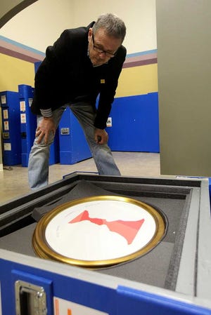 Bruno Marocchini, with the Vatican Museum, looks over a piece that is part of the Pope John Paul II exhibit on Tuesday at the Catholic Renewal Center in Lubbock. The exhibit will be in Lubbock March 15th through May 31st. (Zach Long)