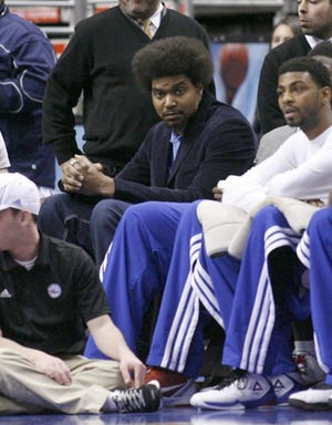 Injured 76ers' center Andrew Bynum sits on the end of the bench during a March 2 home game.