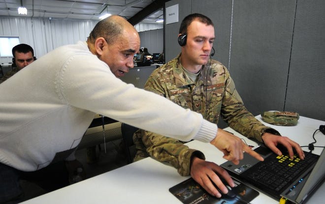 Retired military officer Maurice Mimms, left, works with Air Force Staff Sargeant John Archiquette on his skills during simulated training with the Reconfigurable Vehicle Tactical Trainers at Joint Base McGuire-Dix-Lakehurst. Soldiers, Naval and Air Force personnel work in simulated environments as part of their training before heading off to Afghanistan.