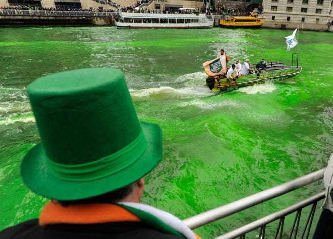 A spectator looks on as the Chicago River is dyed green ahead of the St. Patrick's Day parade in Chicago, Saturday, March, 16, 2013. With the holiday itself falling on a Sunday, many celebrations were scheduled for Saturday because of religious observances. (AP Photo/Paul Beaty)