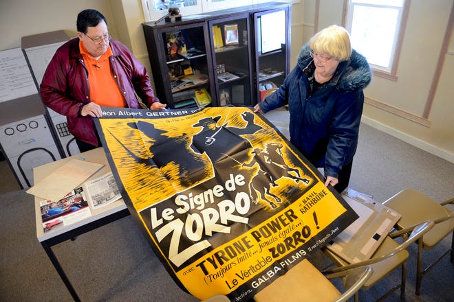 Chillicothe Historical Society president Gary Fyke and society member Dianne Colwell unfold a French movie poster from the film "The Mark of Zorro," starring Tyrone Power and Basil Rathbone, based on a magazine serial written by Johnston McCulley who was raised in Chillicothe. Colwell is chairwoman of a committee dedicated to collecting and displaying McCulley memoribilia that includes the 1908 Argosy magazine that contained the serial, the book "The Mark of Zorro" McCulley wrote after the film was released and a 2012 painting of McCulley by artist Peter Poplaski.