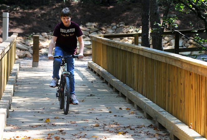Connor Smith rides his bike Sept. 17, 2011, over the new bridge at Cascade Creek in Gadsden, part of the Black Creek Trail.
