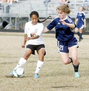 Havelock's Dominique Martinez looks to dribble past D.H. Conley's Megan Jones during a soccer match at Havelock High Monday.