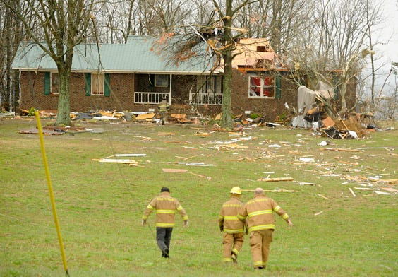 Firefighters walk through a field to check a damaged home on Brow Road after a storm damaged several homes and businesses Monday, March 18, 2013, in Sardis, Ala. Structures were damaged and trees and power lines were down throughout Etowah County. According to reports, two people were injured in the Roden Road area of Sardis.